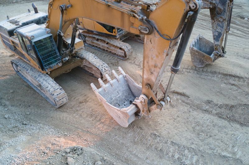 Excavator finishing a limestone slab.