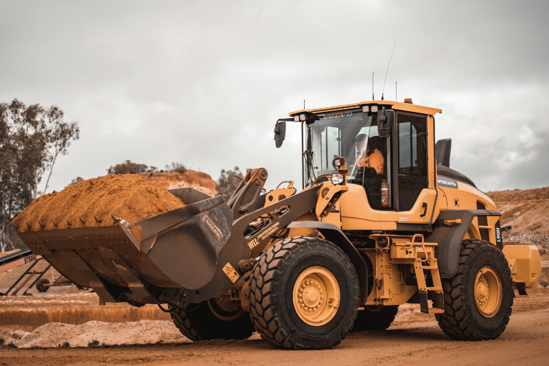 Bulldozer carrying load of sand.